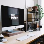 「DO MORE.」と表示されたモニターが置かれた、整理されたワークスペース